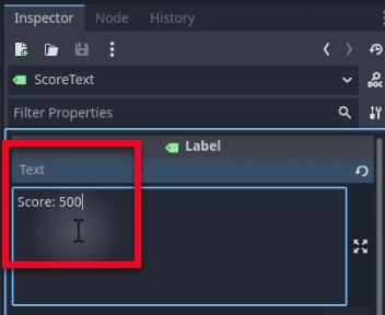 Al tauler Inspector d'un editor de motors de jocs, el node d'etiqueta seleccionat anomenat "ScoreText" es mostra amb la seva propietat Text ressaltada i s'estableix en "Puntuació: 500", que indica el valor de visualització de la puntuació actual per a la IU; això segueix les instruccions de la lliçó per crear un element de text sota CanvasLayer per mostrar la puntuació del jugador, situat a sota del HealthContainer.