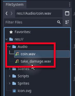 La imatge mostra el moll del sistema de fitxers del motor Godot, destacant la carpeta "Àudio" a "res://", que conté dos fitxers d'efectes de so: "coin.wav" i "take_damage.wav", els actius exactes a què es fa referència a la lliçó per reproduir àudio en recollir una moneda o fer malbé. Els camins dels fitxers que es mostren coincideixen amb els utilitzats als exemples d'script (p. ex., preload ("res://Audio/take_damage.wav")), confirmant la seva ubicació per a la integració amb el node AudioStreamPlayer a l'escena del reproductor.